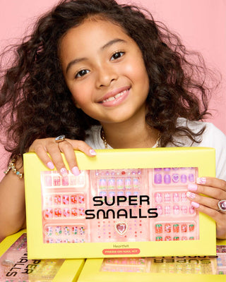 Super Smalls Heartfelt Press On Nail Kit
Young girl holding a 'Super Smalls' product packaging against a pink background