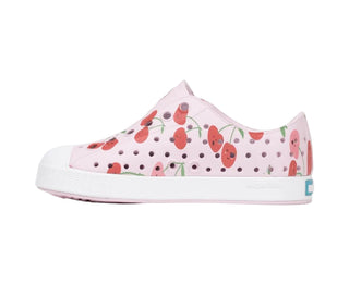 Native Jefferson Print Shoes - Barely Pink / Shell White / Cherries
A single slip-on shoe from K-Swiss, featuring a light pink upper with a red cherry and green leaf pattern, a white rubber toe cap, and a white midsole with a small blue brand tab on the heel.