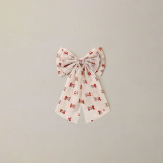 Noralee Alice Bow - Ruby Bows
A fabric hair bow with a repeating pattern of small red bows and gray bows on a white background, centered against a plain light gray wall.