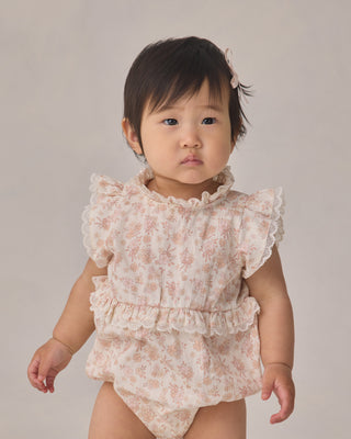 Noralee Alice Romper - Ivory
Baby wearing a floral romper against a plain background