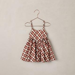 Noralee Betsy Dress - Holiday Tartan
A toddler girl's sleeveless dress with a red and cream gingham check pattern, hanging on a rose gold metal hanger against a textured beige wall.