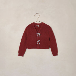 Noralee Bow Cardigan - Ruby
Red cardigan on a hanger against a beige background