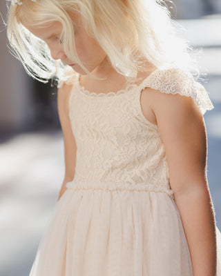 Noralee Camilla Dress - Pearl
Young girl wearing a light pink lace dress with a blurred background