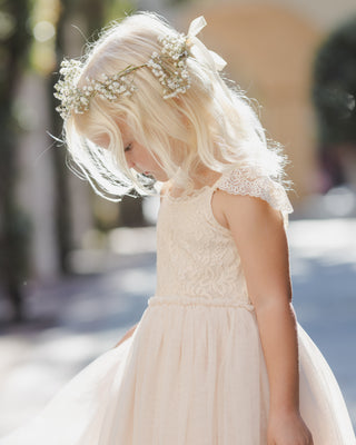 Noralee Camilla Dress - Pearl
Young girl in a white dress with floral headband outdoors