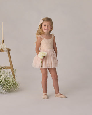 Noralee Camilla Tutu - Pearl
Young girl in a pink dress holding flowers against a neutral background