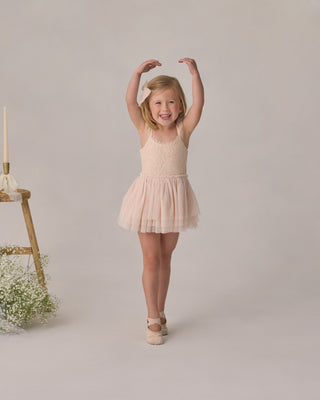 Noralee Camilla Tutu - Pearl
Young girl in a beige tutu dress posing with arms raised on a plain background