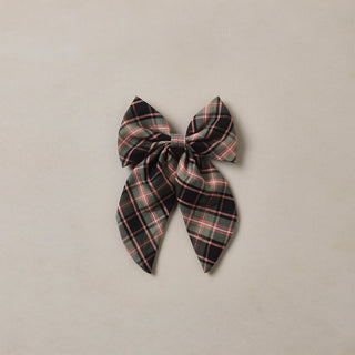 Noralee Everly Bow - Tartan
A fabric hair bow with a black, gray, and pink plaid pattern, centered on a light beige background.