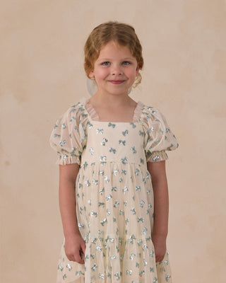 Noralee Louella Dress - Bows
Young girl wearing a floral dress against a plain background