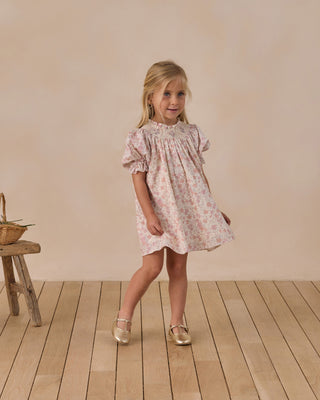 Noralee Maddie Dress - Pastel Garden
Young girl in a floral dress standing on a wooden floor with a plain background