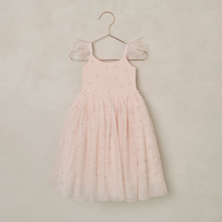 Noralee Poppy Dress - Blush
Pink dress with ruffled sleeves on a hanger against a beige background