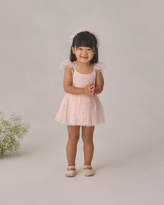 Noralee Poppy Tutu - Blush
Young girl in a pink dress standing against a plain background