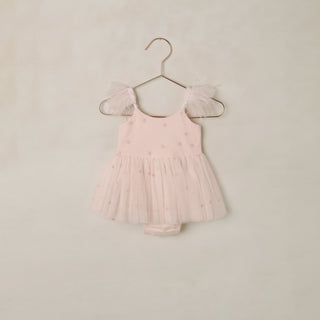 Noralee Poppy Tutu - Blush
Pink dress with sheer sleeves on a hanger against a beige background