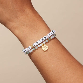 Little Words Project Bracelet - Be F*cking Nice
Bracelet with letter beads spelling 'BE F*CKING NICE' on a wrist against a beige background