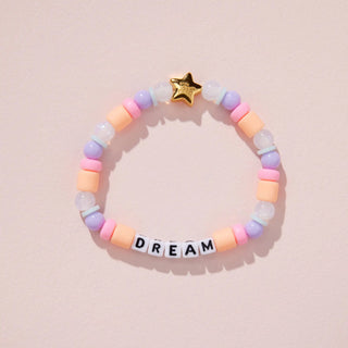 Little Words Project kids bracelet with a charm that says "Dream" featuring colorful beads and a silver clasp.