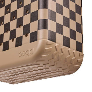 Original Bogg® Bag - Checkered: Camel / Hot Cocoa
Close-up of a Bogg storage bin corner showing a beige and black checkerboard pattern on the sides and a textured beige base, with the Bogg logo embossed on the corner.