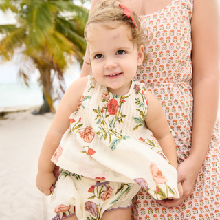Pink Chicken Baby Girls Jaipur 2pc  Set - Rosewick Poppy
Young girl in a floral outfit standing next to an adult on a beach.