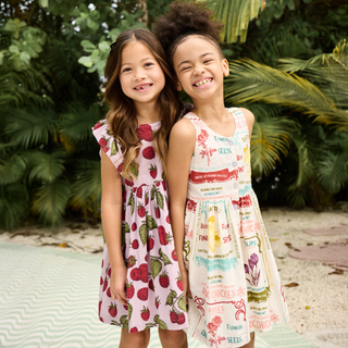 Pink Chicken Girls Elsie Dress - Lavender Raspberries
Two young girls wearing floral dresses standing outdoors with greenery in the background