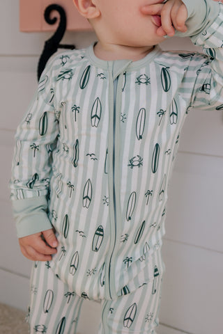 In My Jammers green zipper romper pajamas with surf-inspired print, shown flat with open zipper and long sleeves.