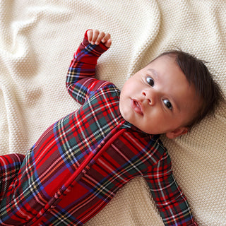 Posh Peanut Footie Zippered One Piece - Red Tartan Plaid
Baby wearing a red plaid outfit lying on a beige blanket