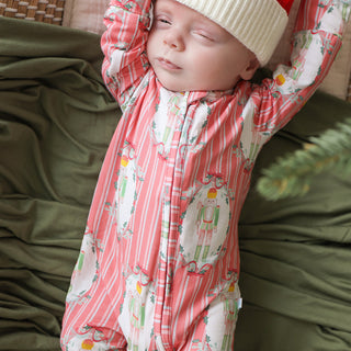 Posh Peanut Footie Zippered One Piece - Sable
Baby in a pink and white patterned outfit and hat lying on a green surface.