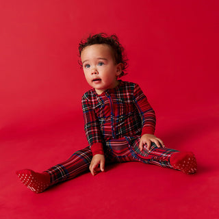 Posh Peanut Convertible One Piece - Red Tartan Plaid
Baby wearing red plaid pajamas sitting on a red background