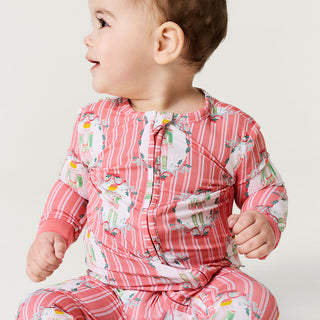 Posh Peanut Convertible One Piece - Sable
Baby wearing a pink and white patterned outfit on a plain background