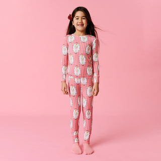 Posh Peanut Classic Pajama Set - Sable
Young girl wearing pink pajamas with a pattern on a pink background