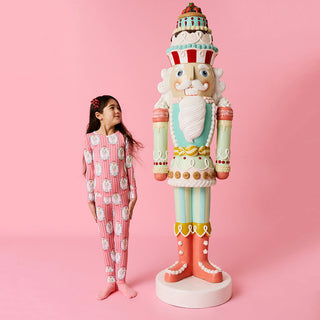 Posh Peanut Classic Pajama Set - Sable
Decorative nutcracker figure next to a child in pajamas on a pink background