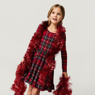 Posh Peanut Ruffled Twirl Dress - Red Tartan Plaid
Young girl wearing a red plaid dress with tinsel accents on a light gray background