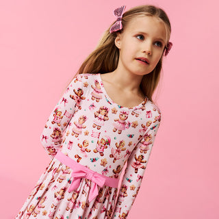 Posh Peanut Bow Twirl Dress - Ginger Posh
Young girl wearing a teddy bear patterned nightgown with a pink bow on a pink background