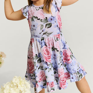 Posh Peanut Marion tie back ruffled twirl dress for girls, pink with ruffle details, displayed on a child in a lifestyle setting.