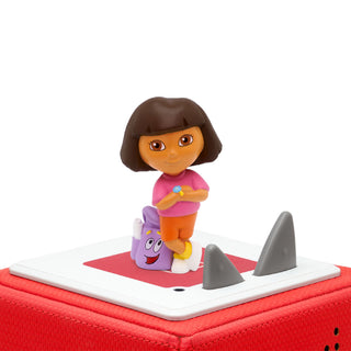 Tonies Character: Dora the Explorer
Dora the Explorer toy figure on a red suitcase with a shark toy.