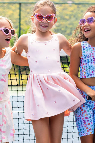 Peach Lola & The Boys Heart Scuba Tennis Dress displayed on a hanger, showcasing its vibrant color and stylish design.