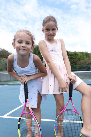Lola & The Boys peach heart scuba tennis dress displayed on a hanger, showcasing its vibrant color and playful design.