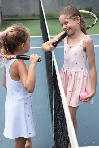 Peach Lola & The Boys Heart Scuba Tennis Dress displayed on a hanger, showcasing its vibrant color and sporty style.