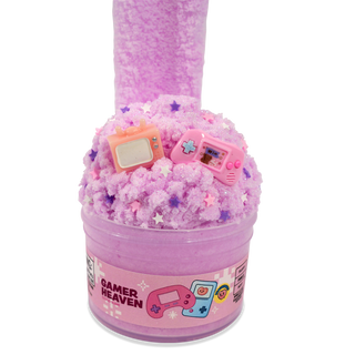 Peachybbies Cloud Slime - Gamer Heaven
A pink slime bucket toy with a clear plastic container labeled 'GAMER HEAVEN' and decorated with miniature gaming consoles and star-shaped sprinkles on top, set against a plain white background.