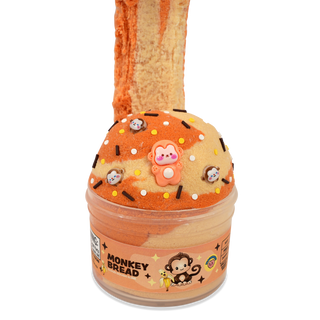 Peachybbies Cloud Slime - Monkey Bread 
A novelty slime jar shaped like a donut, labeled 'MONKEY BREAD' on the front. The jar contains orange and beige marbled slime, topped with sprinkles, chocolate pieces, and a pink monkey charm.