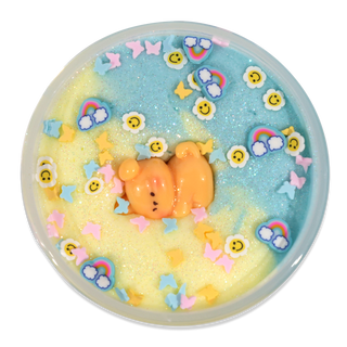 Peachybbies Cloud Slime - Puppy Playtime
A round decorative item with a translucent lid, filled with pastel blue and yellow glittery slime and decorated with small rainbow, smiley face, butterfly, flower, and star embellishments, plus a small orange bear figure in the center.