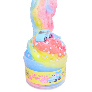 Peachybbies Icee Slime - Car Wash Foam
 A cup of rainbow-colored slime topped with a small light blue toy car, with a long curl of pink, blue, and yellow slime rising above the cup. The cup has a yellow label that reads 'CAR WASH FOAM' with a cartoon car illustration.