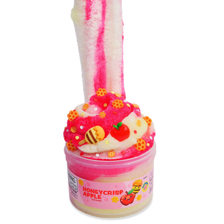 Peachybbies Icee Slime - Honey Crisp Apple
A pink and white slime toy shaped like a cupcake or dessert in a clear plastic tub labeled 'HONEYCRISP APPLE'. The product features a thick, stretchy pink and white slime column rising from the top, decorated with small yellow honeycomb sprinkles, a red apple, and a bee topper, set against a plain white background.