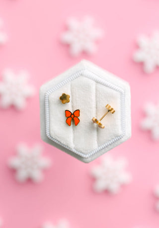 Pierced Co. Red Bow Earrings
Hexagonal jewelry display with butterfly earrings on a pink background