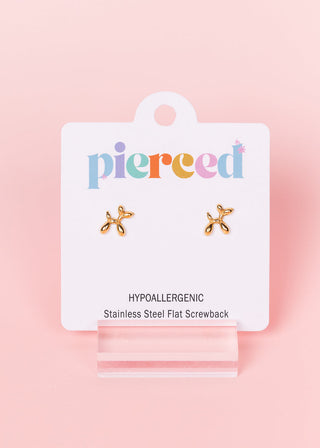 Pierced Co Earrings - Balloon Dog
A pair of small gold flat screwback stud earrings shaped like a dog toy, displayed on a white 'pierced' brand jewelry card with a clear acrylic stand against a soft pink background.
