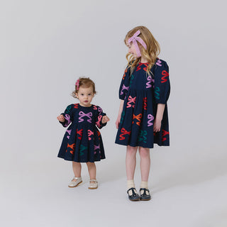 Pink Chicken Girls Brooke Dress - Multi Bow Applique
Two children wearing matching dresses with colorful patterns on a plain background