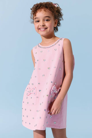 Pink denim dress with crystal heart embellishments and a bow detail, by Lola & The Boys, shown on a young girl model.