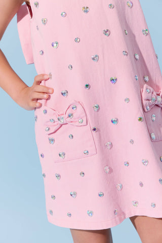 Pink denim dress with a crystal heart embellishment and bow detail from Lola & The Boys, perfect for stylish young girls.