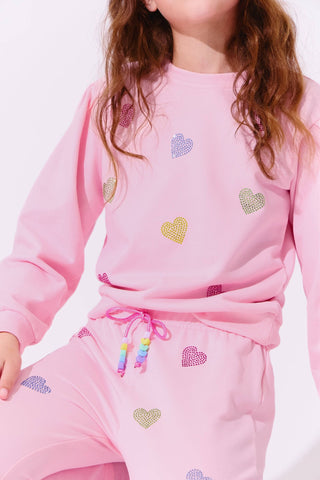 Lola and The Boys Pink Crystal Hearts Set
Child wearing a pink outfit with heart patterns on a light background