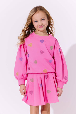 Lola and The Boys Hot Pink Sparkle Hearts Skirt Set
Young girl wearing a pink outfit with heart patterns on a white background