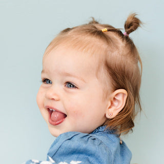 Pip Pop Post Earrings - Pink Petite Flower
Child with pigtails sticking out tongue against a light blue background
