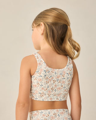 Play by Rylee & Cru Swift Sports Bra - Flower Field
Young girl wearing a floral crop top and shorts on a beige background