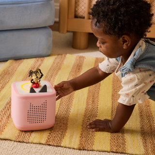 Playtime Puppy Toniebox 2 Starter Set - Cloud Pink
Child playing with a pink toy on a striped rug